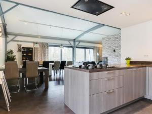 a kitchen and dining room with a counter and a table at Attractive holiday home in Noordwolde with sauna in Noordwolde