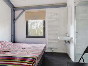 a bedroom with a bed and a sink and a window at Attractive holiday home in Noordwolde with sauna in Noordwolde