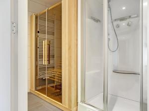 a shower with a glass door in a bathroom at Attractive holiday home in Noordwolde with sauna in Noordwolde +29 photos