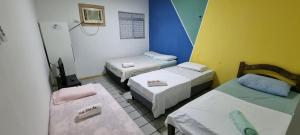 Zimmer mit 3 Betten und 2 Stühlen in der Unterkunft Hotel Beira Mar in Natal