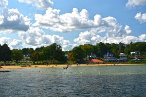 a beach with a group of people in the water at Spacious Condo Walking distance to Weirs in Laconia
