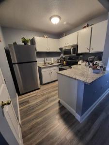 a kitchen with white cabinets and a counter top at Spacious Condo Walking distance to Weirs in Laconia