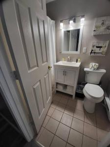 een badkamer met een wit toilet en een wastafel bij Spacious Condo Walking distance to Weirs in Laconia