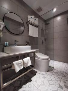 納閩的住宿－OCEAN HOTEL，一间带卫生间、水槽和镜子的浴室