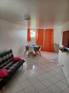 ein Wohnzimmer mit einem Sofa und einem Tisch in der Unterkunft Petit cocon in Les Abymes