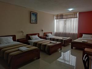 a room with three beds and a window at Hotel Diana Real in Santo Domingo de los Colorados +24 photos
