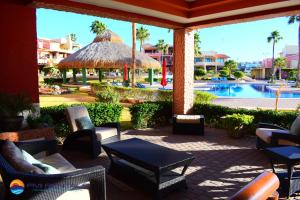 a patio with chairs and tables and a swimming pool at Marina Pinacate B-201 in Puerto Peñasco