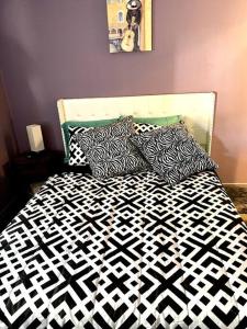 - un lit avec des draps et des oreillers en noir et blanc dans l'établissement New! Fun just 20 min from Dallas 3-BRM Home, à Garland