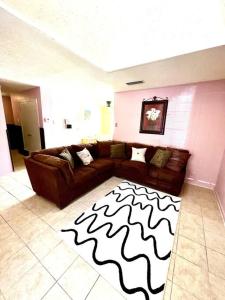 - un salon avec un canapé brun et un tapis noir et blanc dans l'établissement New! Fun just 20 min from Dallas 3-BRM Home, à Garland