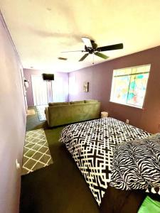 - une chambre avec un lit à motifs zébrés et un ventilateur de plafond dans l'établissement New! Fun just 20 min from Dallas 3-BRM Home, à Garland