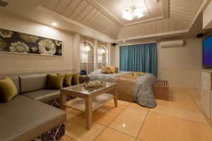Habitación con cama, sofá y mesa. en ホテルウォーターゲート岡山 en Okayama