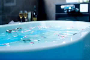 una vasca da bagno riempita di liquido blu con spruzzi di ホテルウォーターゲート岡山 a Okayama