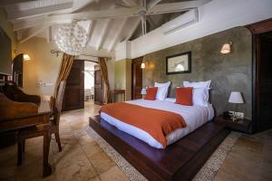 a bedroom with a large bed and a desk at La Villa Hibiscus, Saint Martin in Saint Martin
