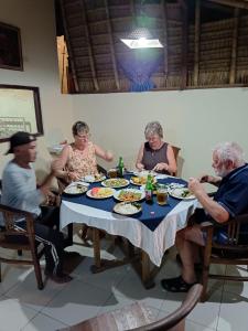 een groep mensen die rond een tafel eten bij Jana's Homestay in Sidemen