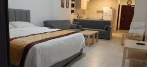 a bedroom with a bed and a living room with a kitchen at Al Raha Village Aqaba in Aqaba +21 photos