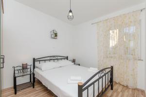 a bedroom with a black bed and a window at Apartments Marina in Postira