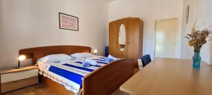 um quarto com uma cama e uma mesa com um cobertor azul em Apartment Close to the beach em Stari Grad