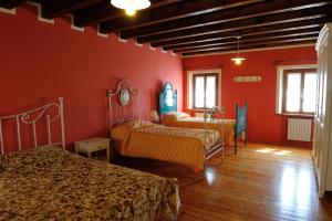 a bedroom with two beds and red walls at Agriturismo Crodi in Miane