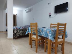 Un comedor con una mesa y sillas y una cama. en DEPARTAMENTO CON COCHERA ( COMPLEJO FRENCH ), en La Rioja 9 fotos más