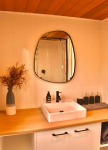 a bathroom with a white sink and a mirror at Ketchup's Bank Glamping in Boonah