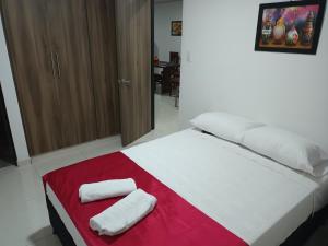 a bedroom with a bed with two towels on it at Apartamento turístico amoblado Barbosa in Barbosa