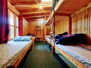 a bedroom with three bunk beds in a wooden cabin at Mowgli Town Homestay/Resort in Nainital
