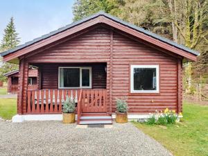 a log cabin with a porch and windows at Willow Lodge in Rashfield