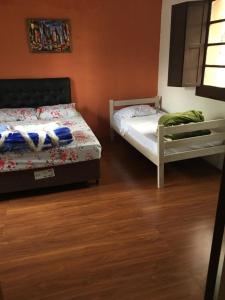1 Schlafzimmer mit 2 Betten und Holzboden in der Unterkunft N6-CASA CÉNTRICA 2 DORMITORIOS Con AIRE ACONDICIONADO in Artigas