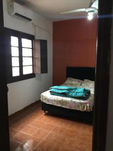 Un dormitorio con una cama en una habitación con ventana. en N6-CASA CÉNTRICA 2 DORMITORIOS Con AIRE ACONDICIONADO, en Artigas