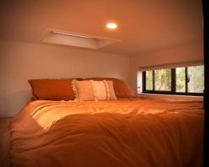 ein großes Bett in einem Zimmer mit Fenster in der Unterkunft Ketchup's Bank Glamping in Boonah