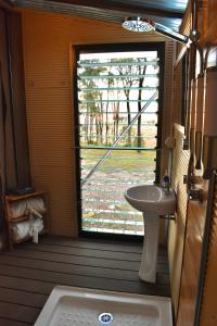 uma casa de banho com um lavatório e uma janela em Ketchup's Bank Glamping em Boonah