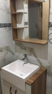Un baño con un lavabo blanco y un espejo. en N6-CASA CÉNTRICA 2 DORMITORIOS Con AIRE ACONDICIONADO, en Artigas
