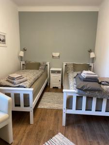 twee bedden in een kamer met houten vloeren bij Little Cottage in Visselhövede