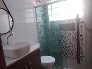 ein Bad mit einem Waschbecken, einem WC und einer Dusche in der Unterkunft Praia Grande Apartamento Aconchegante pertinho da Praia - 300m in Praia Grande