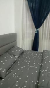 a bedroom with a bed with a blue curtain at AZhomestay in Jitra