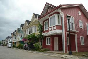 a row of colorful houses on a street at Pontefino Prime Townhouse 4BR with Wifi & Pool in Batangas City