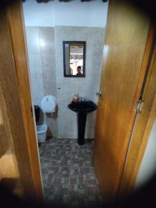 ein Badezimmer mit einem Waschbecken, einem WC und einem Spiegel in der Unterkunft Hotel Estaciones in Guatapé