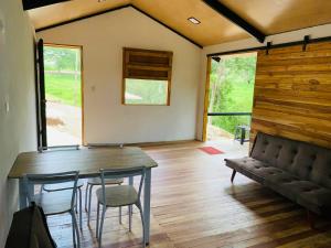 una sala da pranzo con tavolo, sedie e divano di Cabañas del Bosque a Nandayure