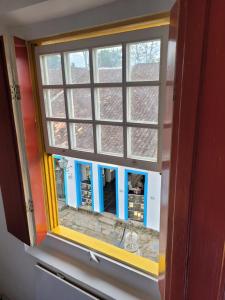 une fenêtre dans un mur avec une réflexion dans l'établissement Pousada Casa Da Lapa, à Parati