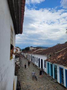 Un groupe de personnes marchant dans une rue avec des bâtiments dans l'établissement Pousada Casa Da Lapa, à Parati