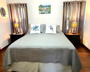 a bedroom with a large bed with two lamps at Phoenix House in Sandy Bay