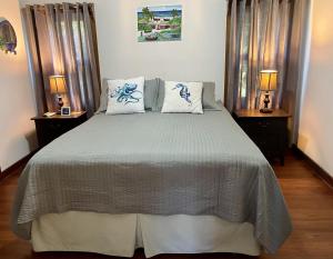 1 dormitorio con 1 cama grande y 2 mesitas de noche en Phoenix House en Sandy Bay