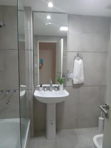 a white bathroom with a sink and a shower at Depto en el corazon de barrio norte in San Miguel de Tucumán