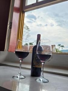 two glasses of wine sitting on a table with a window at Pousada Casa Da Lapa in Paraty