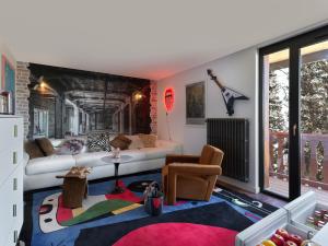 a living room with a couch and a table at Snow Lodge Hotel Courchevel 1850 in Courchevel