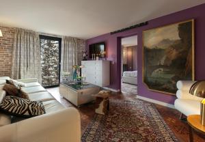 a living room with purple walls and white furniture at Snow Lodge Hotel Courchevel 1850 in Courchevel