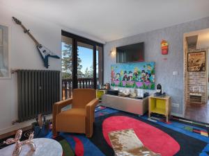 a living room with a guitar on the wall at Snow Lodge Hotel Courchevel 1850 in Courchevel