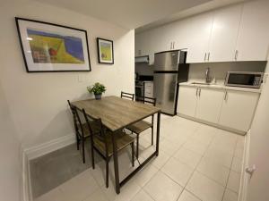 a kitchen with a wooden table and chairs in it at Yorkmills and Bayview !B Spacious and Stylish Private Bdr with Shared Bathroom in Toronto