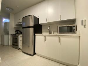 a kitchen with white cabinets and a stainless steel refrigerator at Yorkmills and Bayview !B Spacious and Stylish Private Bdr with Shared Bathroom in Toronto