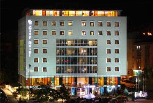 アンカラにあるCity Hotel Ankaraの夜間の照明付き窓のある白い大きな建物